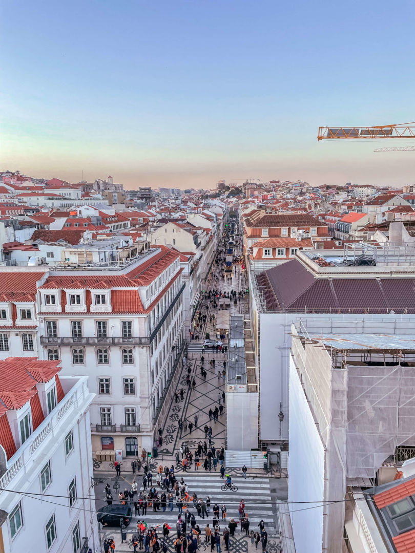 Vista da rua Augusta em Lisboa do alto do Mirante. A imagem é simétrica com a rua no meio e a luz é do final do dia.