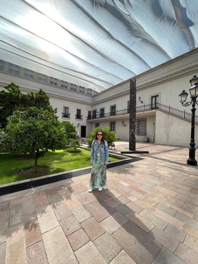 Por dentro do Palacio de la Moneda, com um jardim verde no meio do saguão. Ele é a céu aberto, mas está coberto por um tecido branco para proteger do sol.